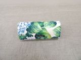 a white and blue flowered purse on a table