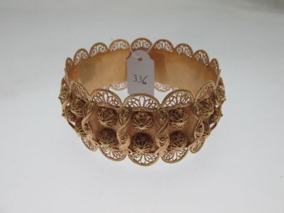 gold filigreed bracelet with a tag on it