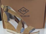 the woman is wearing a pair of wedged sandals in front of a cardboard box