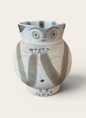 un vase blanc orné d'un motif représentant un hibou
