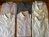 four men ' s dress shirts lined up on a wooden table