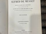 un livre ouvert posé sur une table à côté d'une pile de livres