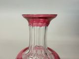 a glass vase with a pink base sitting on a table