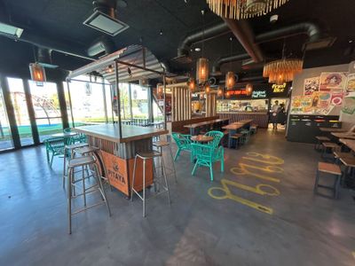 Ce restaurant, qui donne sur la piscine, dispose de nombreuses tables et chaises.