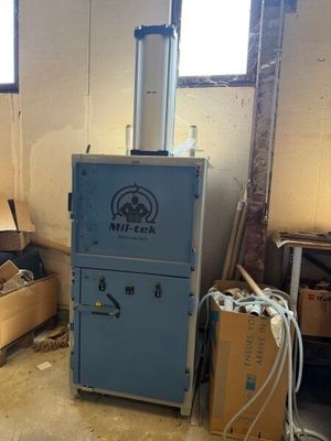 une machine bleue dans une pièce remplie de caisses en bois