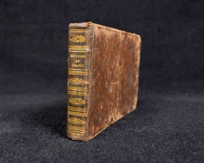 un vieux livre posé sur une table recouverte d'un tissu noir