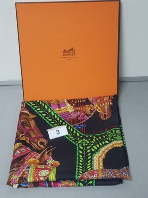 a black and orange scarf with an orange box on top of it