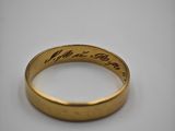 a close up of a gold ring with writing on it