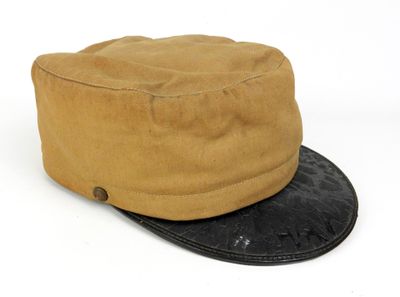 chapeau beige et noir avec un bord en cuir sur le dessus