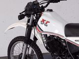 a motorcycle parked in a garage with a white wall in the background