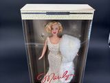 the barbie doll is in a clear box with a white fur
