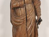 a wooden statue of a woman holding a bag