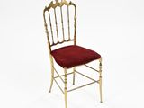 an image of a gold chair with a red cushion on it