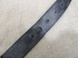 a close up of a black leather belt on a pillow