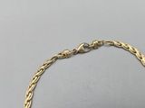 a close up of a gold bracelet on a gray surface