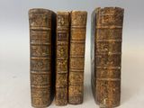 trois vieux livres posés l'un sur l'autre sur une table