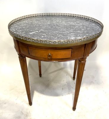 une photo d'une table au plateau en marbre, avec un tiroir en dessous