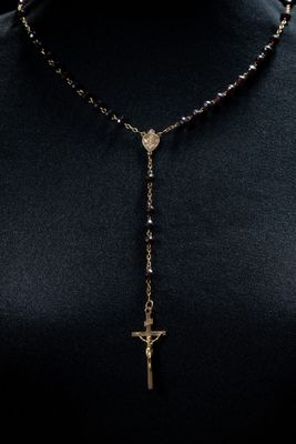 a woman wearing a black shirt and a gold cross necklace