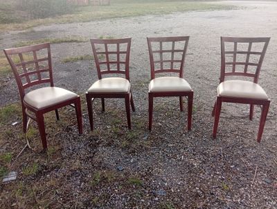 four chairs sitting in a row in the middle of a gravel field