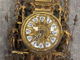 a gold clock with a roman numeral on it