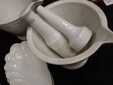 a white bowl with a mortar and a spoon in it