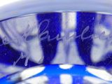 a close up of a blue glass vase with a white background