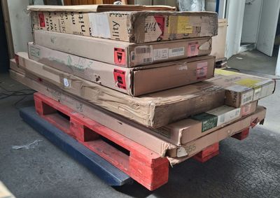 une pile de cartons posée sur une palette dans un garage