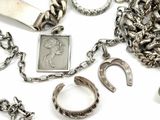 a lot of silver jewelry on a white surface