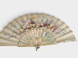 un vieux ventilateur orné de fleurs sur fond blanc