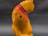 a yellow dog figurine with a red collar on it