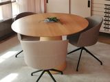 une table avec des chaises et un vase posé dessus, dans une pièce