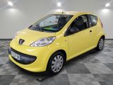 La petite voiture jaune est garée sur un sol à damier.