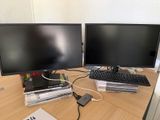 deux écrans d'ordinateur posés sur un bureau en bois