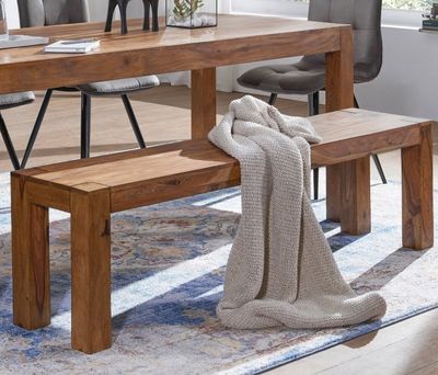 a wooden table with a bench in the middle of the room