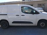 the white van is parked in the parking lot next to the building