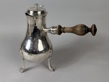 an antique silver coffee pot with a wooden handle on a stand