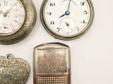 three different types of pocket watches and a lighter on a white surface