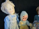 three dolls sitting next to each other on a black background