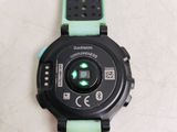 a close up of a watch on a white surface with a green band