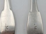 two spoons that are sitting next to each other on a table