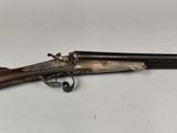 an old gun with a wooden handle on a white surface