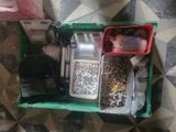 a green box filled with assorted items on top of a tiled floor