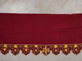un gros plan sur une nappe rouge bordée de jaune