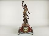 a statue of a woman holding a clock on a table