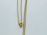 a close up of a necklace with a blue heart on it