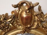 a mirror with a gold frame with a bird and flowers on it