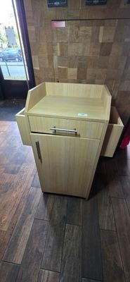 a wooden cabinet with a drawer on it in a room