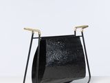 un porte-revues en cuir noir posé sur une surface blanche