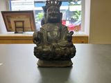 a statue of buddha sitting on a table in front of a window