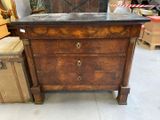 a wooden chest of drawers with a marble top